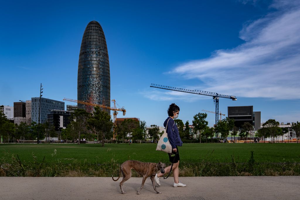 Una dona passeja el gos pel parc de les Glòries