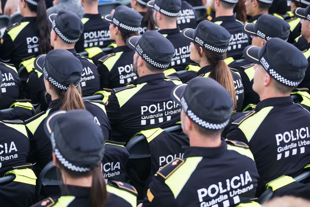 Vista des de dalt d’un grup de la Guàrdia Urbana assegut en l’esdeveniment de benvinguda de les noves promocions de Guàrdia Urbana, on es contempla una multitud de caps i gorres de la policia municipal