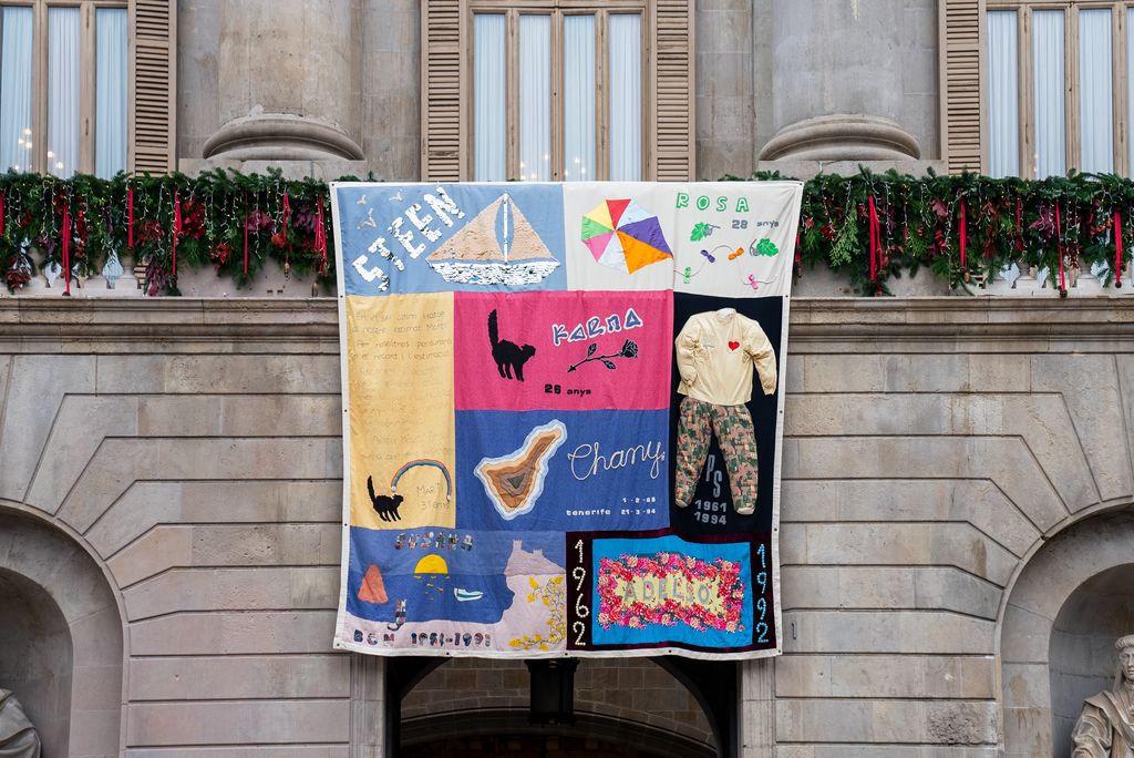 Un tapiz conmemorativo cuelga del balcón del Ayuntamiento de Barcelona en honor al Día Mundial contra el SIDA.