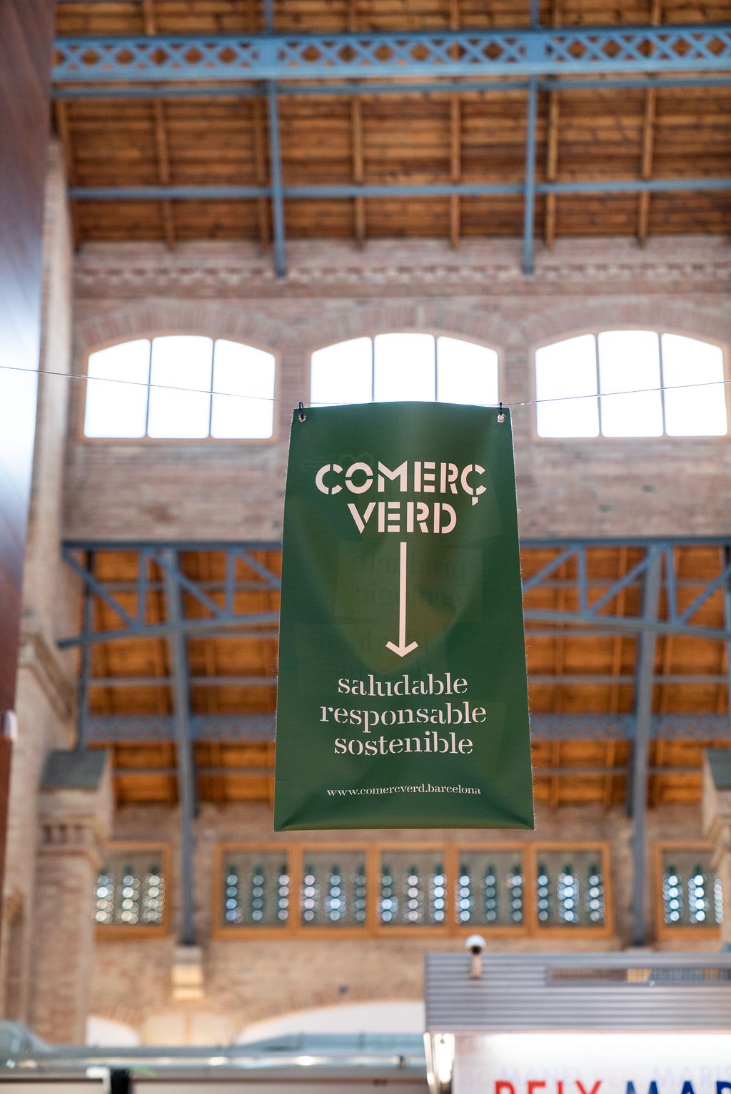 Banderoles de “Comerç verd” penjant del sostre del Mercat de Sants