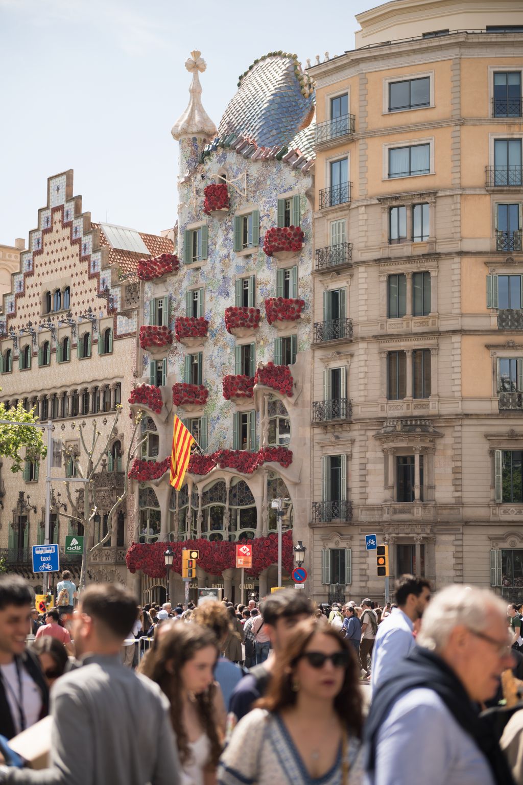 La Casa Batlló decorada amb roses i persones passejant-hi al davant el dia de Sant Jordi