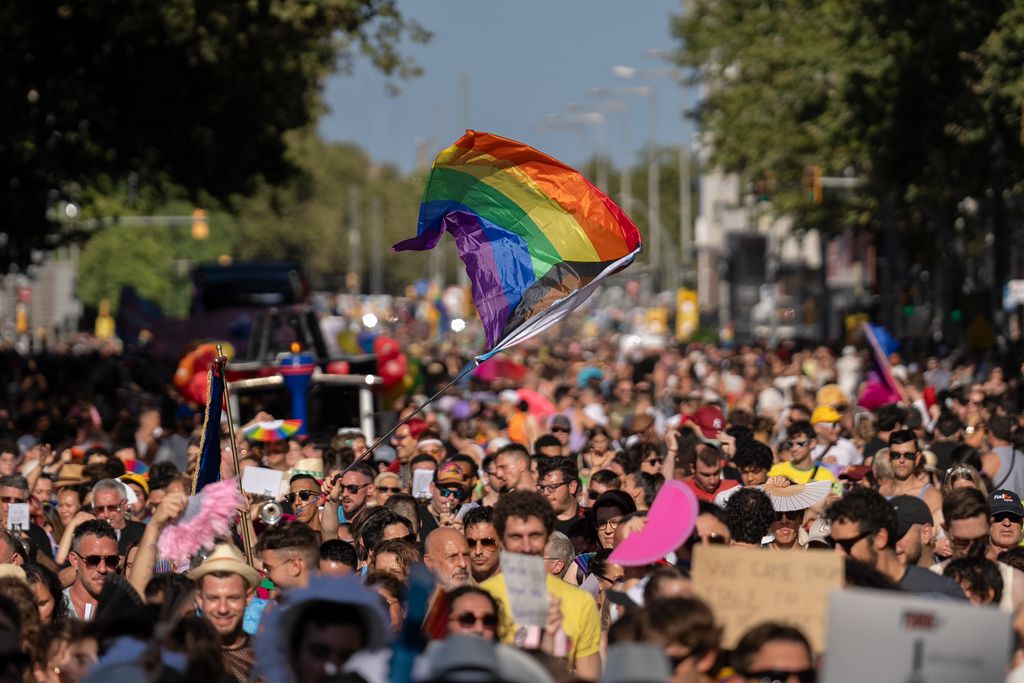 Ambient durant la manifestació del Pride! 2023. Al mig, una gran bandera amb els colors LGTBI.