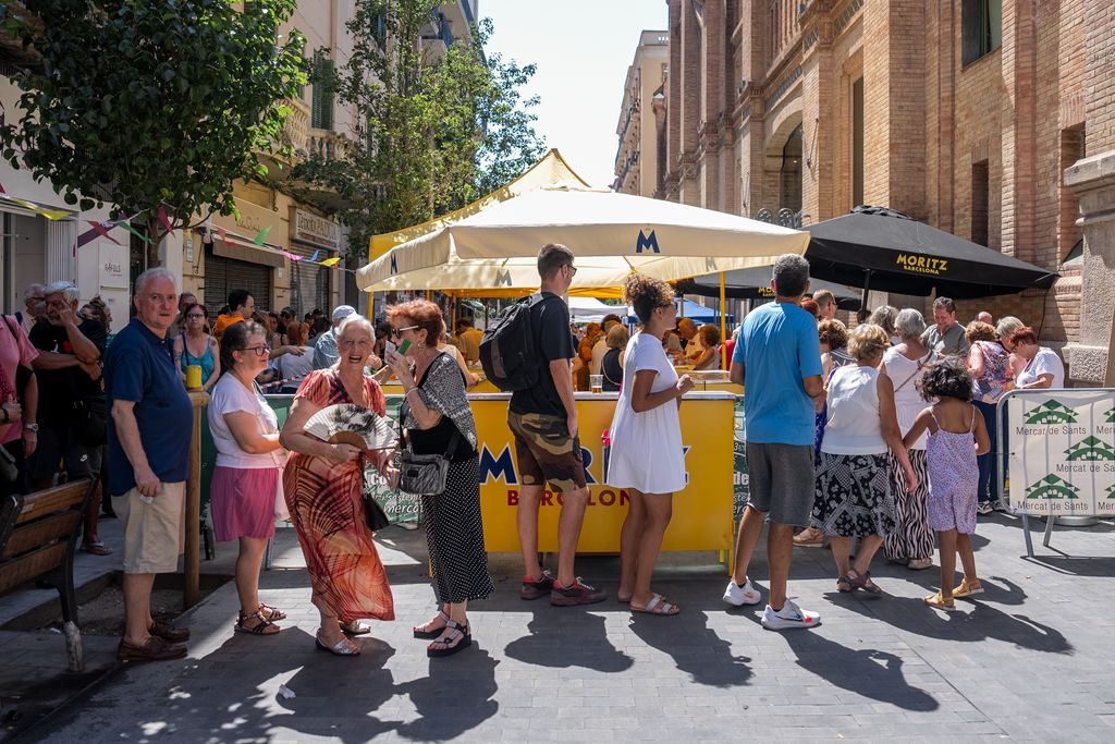 Ambient de la cua de repartiment de menjar i begudes del 'Vermutet Mariner' organitzat pel Mercat de Sants.