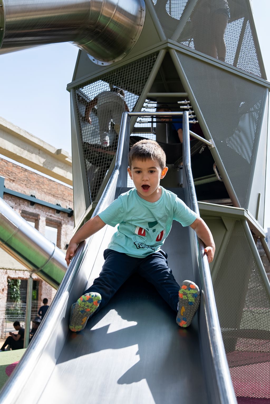 Un nen baixa pel tobogan instal·lat a l’àrea de jocs de Can Batlló.