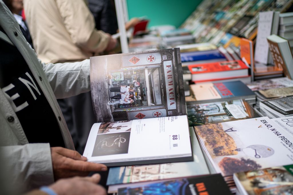 Una persona fulleja un llibre a la parada de Barcelona Llibres instal·lada a la superilla literària de Sant Jordi