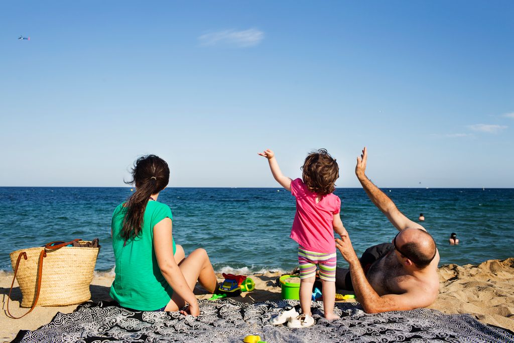 Família jugant a la platja