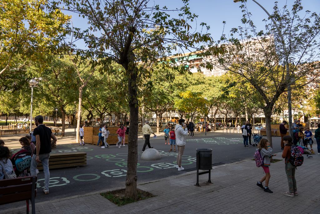 Famílies i infants a l'entorn de l'Escola Lavínia caminant per la vorera i la zona pacificada davant del centre educatiu