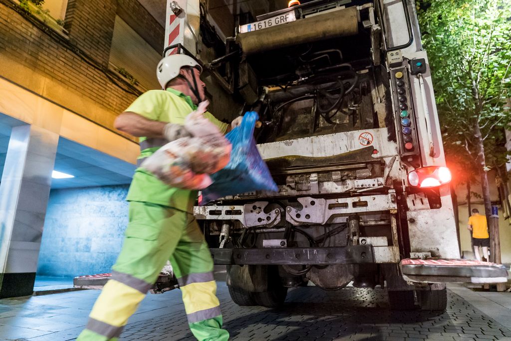 Recollida selectiva porta a porta al barri de Sarrià. Escombriaire introduint les bosses de brossa al camió