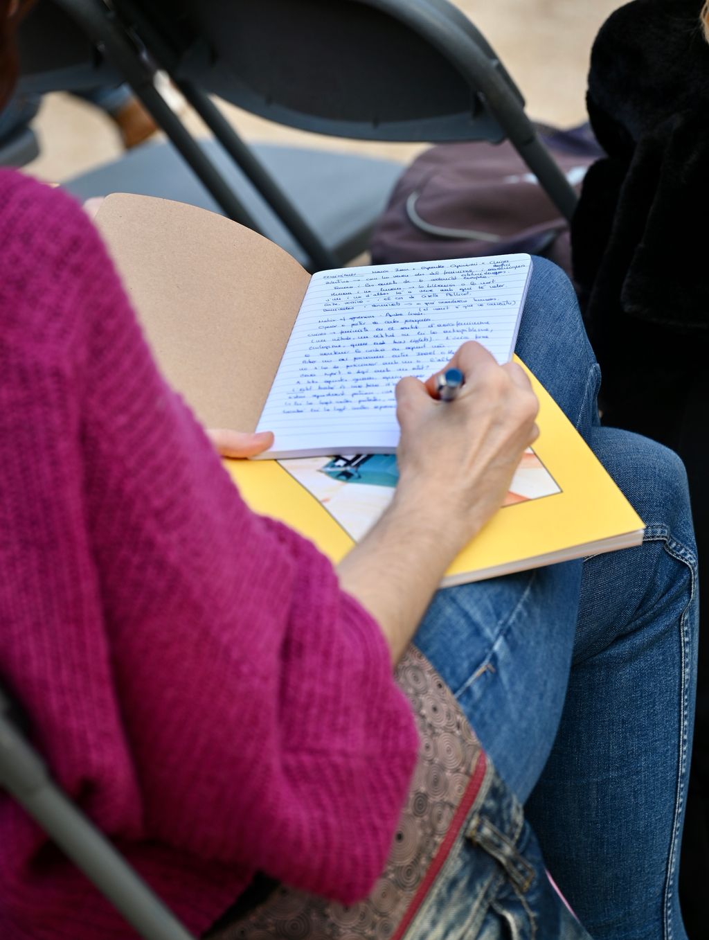 Una noia pren notes en una llibreta durant la conversa "Feminismes" de la Biennal de Pensament 2024