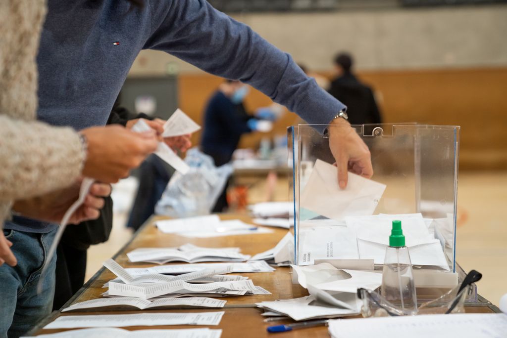 Un membre d'una mesa treu els vots d'una urna per fer el recompte, al CEM L'Espanya Industrial
