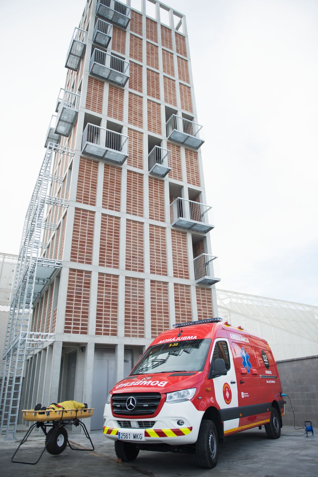 Una ambulància dels Bombers de Barcelona i una llitera davant la nova torre de pràctiques del Parc de Bombers de la Vall d'Hebron