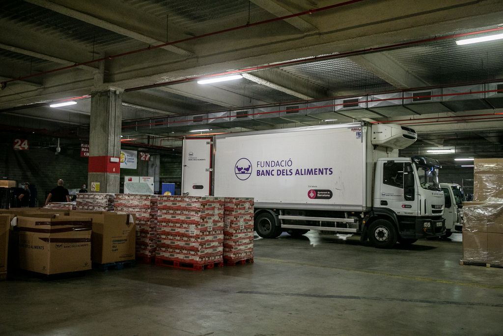 Camió del Banc d'Aliments i, al voltant, palets amb matèries primeres