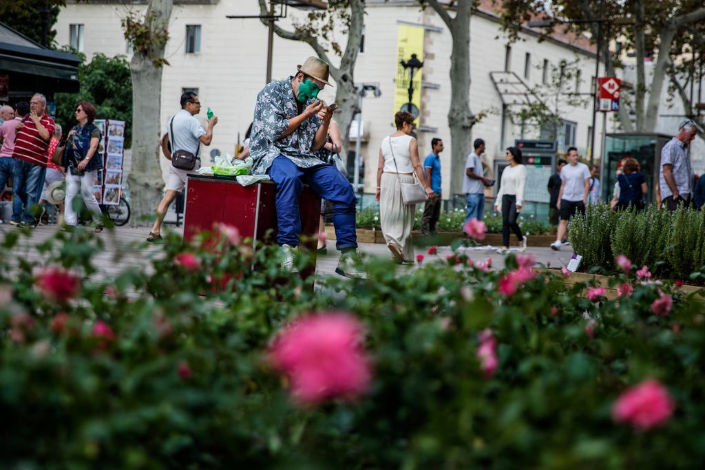 Estàtua humana a la Rambla de les Flors maquillant-se