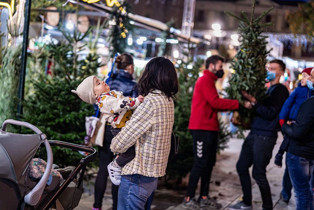 Famílies comprant el tradicional arbre de Nadal a la Fira de Santa Llúcia
