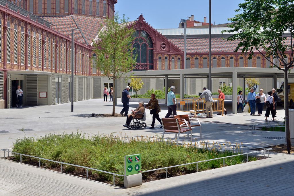 Veïns anant i venint per la zona pacificada de la superilla de Sant Antoni davant del mercat