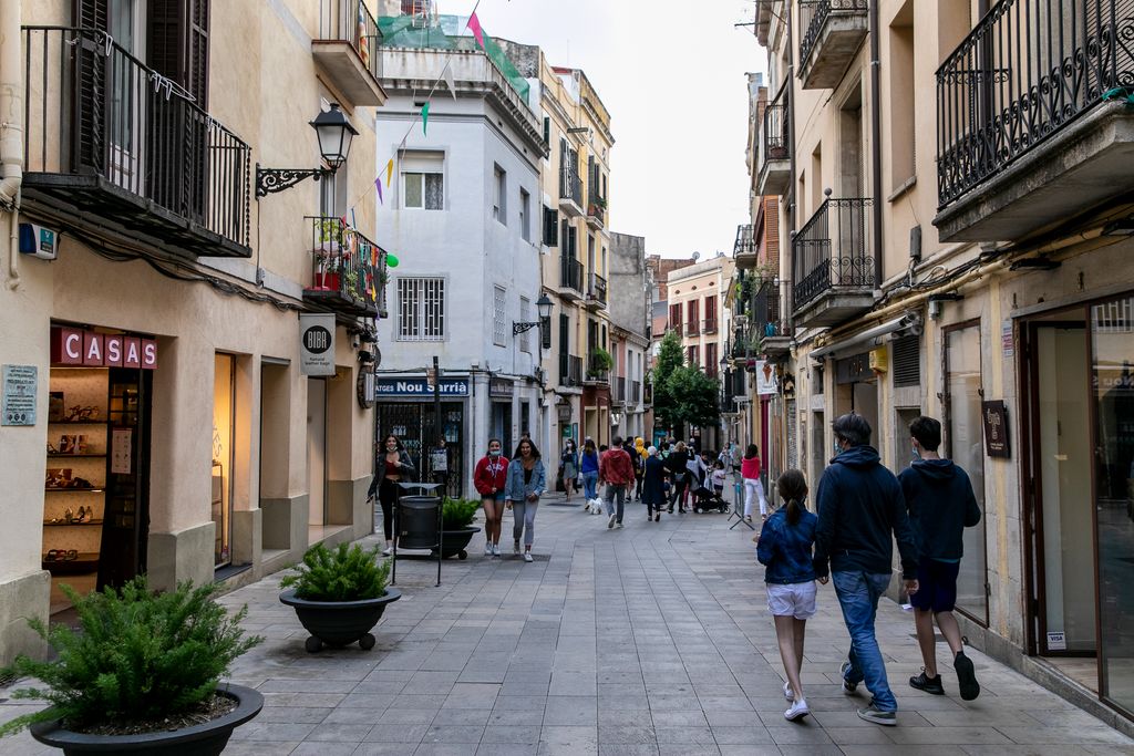 Botigues obertes al carrer Major de Sarrià amb gent passejant i anant de compres