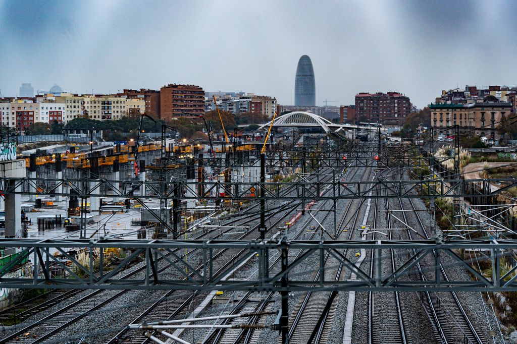 Exterior de l’estació de la Sagrera en el tram al descobert on es poden veure les vies i les catenàries. S’hi veu la Torre Glòries al fons