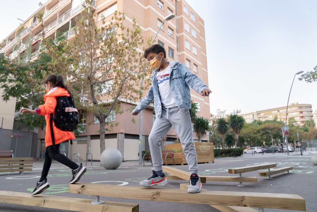 Un infants juguen davant de l'Escola Lavínia, a una zona que s'ha pacificat en el marc del programa 'Protegim les escoles'