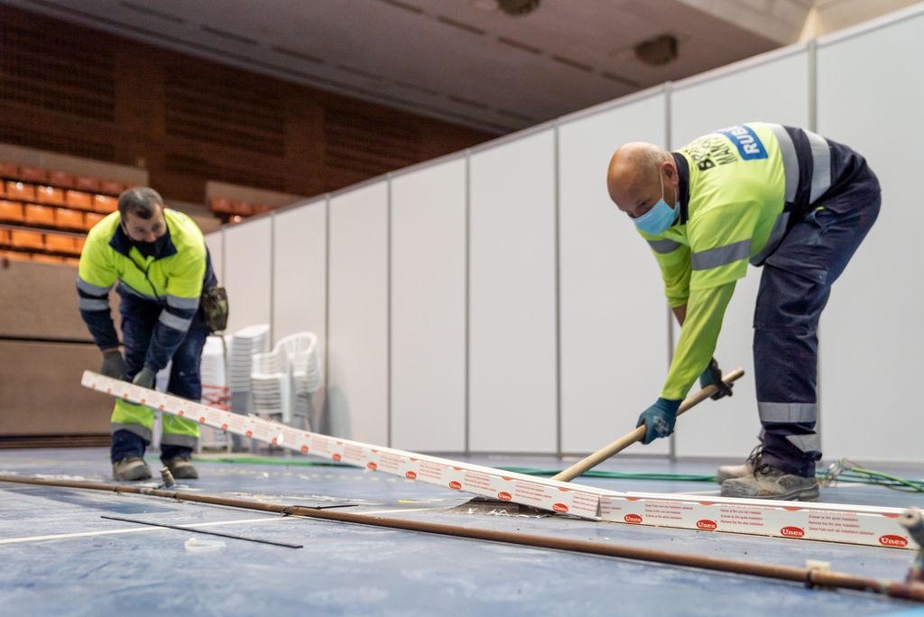 Uns treballadors retiren les canaletes dels cablejats del Pavelló Salut Vall d'Hebron