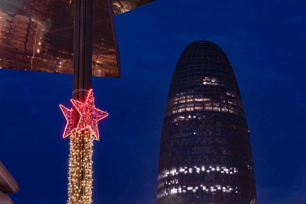 Decoració nadalenca en una de les columnes del Mercat dels Encants. Al fons, la Torre Glòries