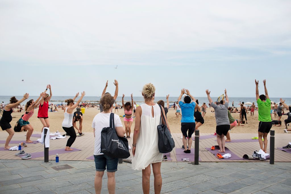 Grup de persones practicant gimnàstica a la platja