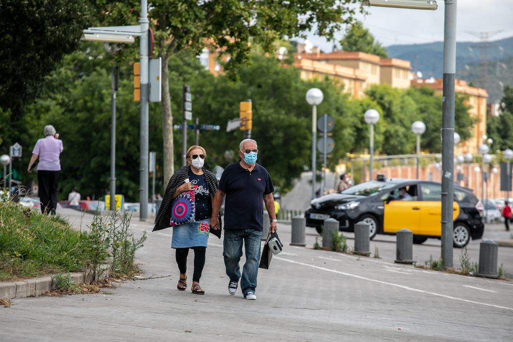 Una parella va caminant prop de la zona de via Júlia amb ronda de Dalt. Ambdós porten mascaretes