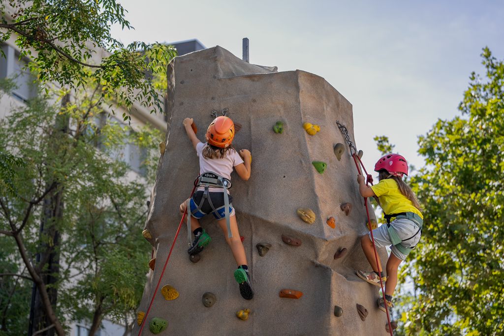 Dues nenes pugen per una paret de rocòdrom com a part de les activitats proposades a la Festa Major d’Horta.