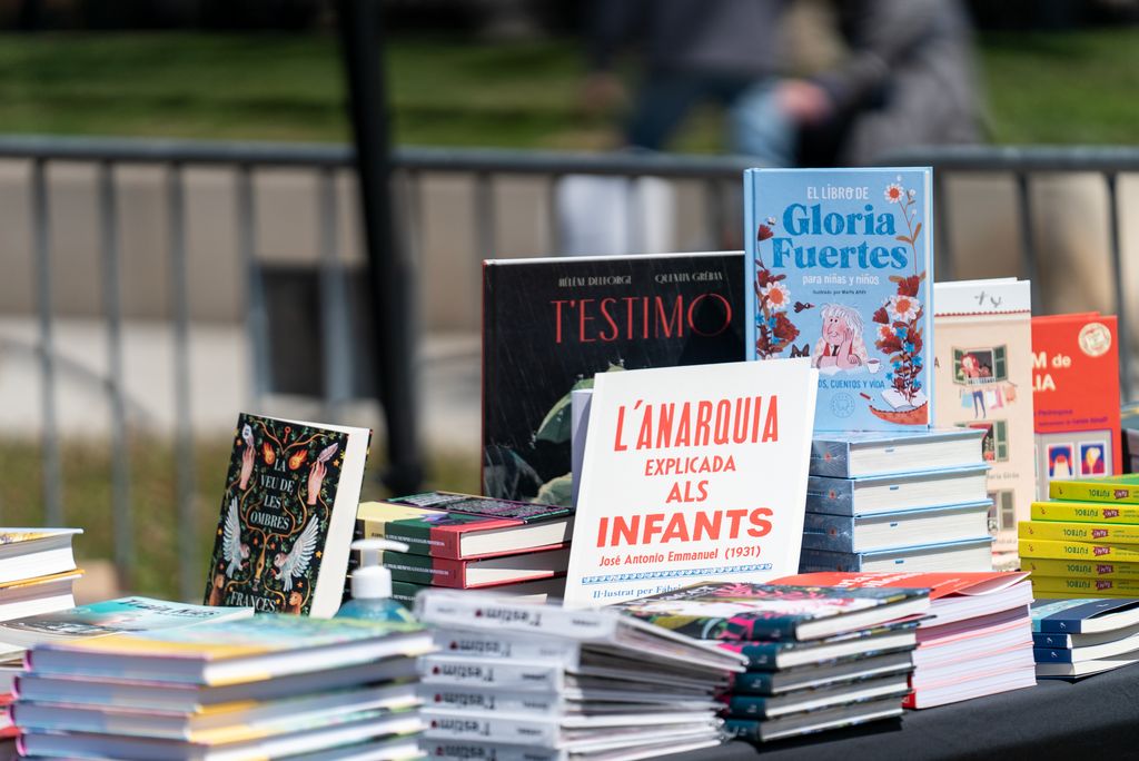 Taulell amb llibres de literatura infantil i juvenil a una parada del recinte firal del passeig de Lluís Companys amb motiu de la diada de Sant Jordi
