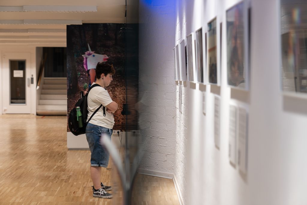 Una persona visita l’exposició fotogràfica “Cora” al Centre LGTBI.
