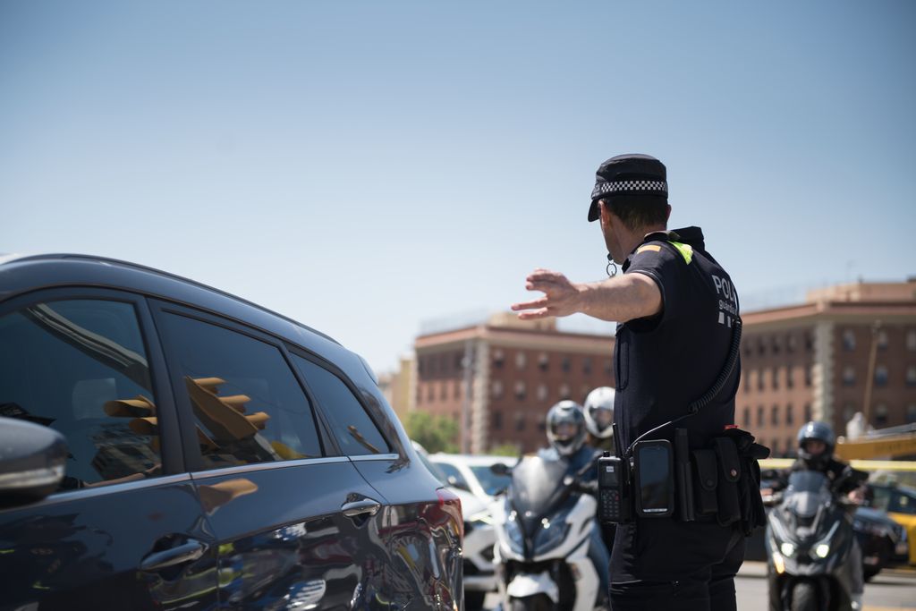 Un agent de la Guàrdia Urbana dirigeix el trànsit de plaça d'Espanya el dia de l'apagada general
