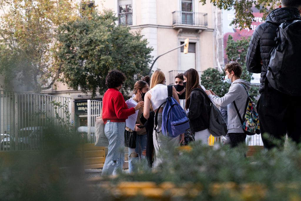 Grup de joves estudiants conversant en cercle a la zona pacificada de vorera ampliada de davant del Col·legi Escolàpies de Llúria