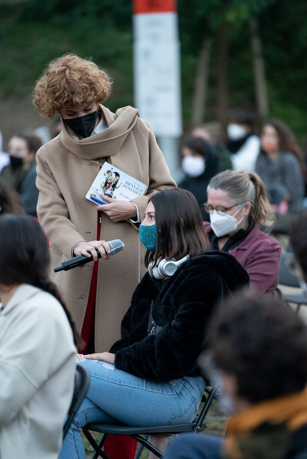 Una dona del públic fa una pregunta als ponents de la taula rodona "L'emergència del futur: Qui representa els qui encara no han nascut?" als jardins del Doctor Pla i Armengol