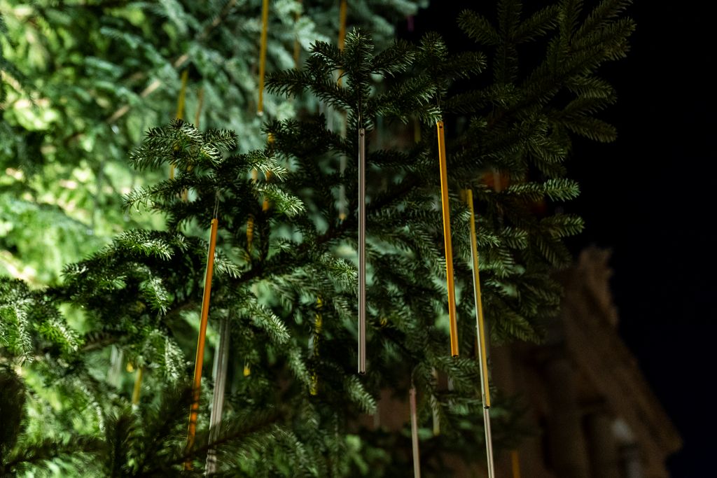 Detalle de la decoración de tubos metálicos del árbol de Navidad de la plaza de Sant Jaume iluminado por la noche