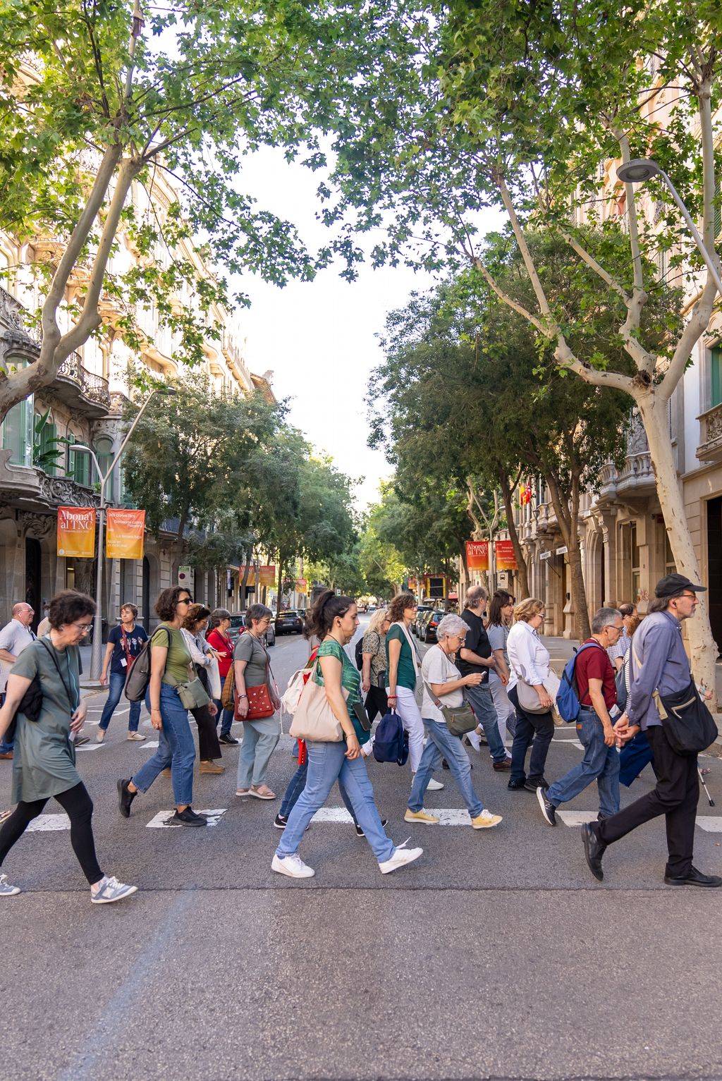 Diferents persones travessant un carrer durant l’itinerari per l’Eixample basat en el llibre ‘La Barcelona esgrafiada’.