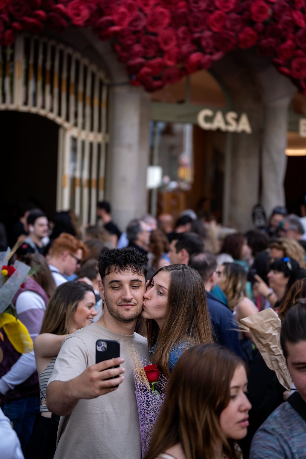 Una parella es fa un selfie davant de la Casa Batlló. Al seu voltant, multitud de persones passejant durant la diada de Sant Jordi 2023.