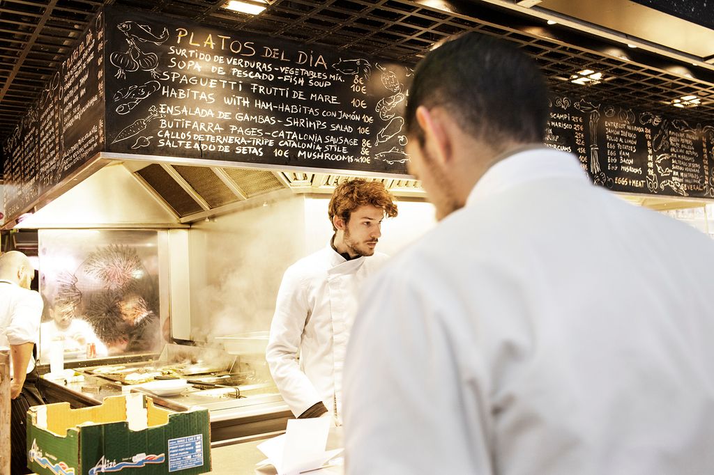 Cuiners i clients d'un establiment de restauració situat a un mercat