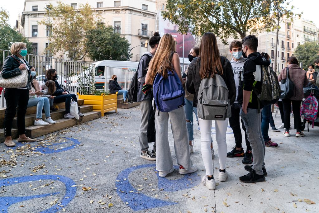Grup de joves estudiants conversant en cercle a la zona pacificada de vorera ampliada de davant del Col·legi Escolàpies de Llúria
