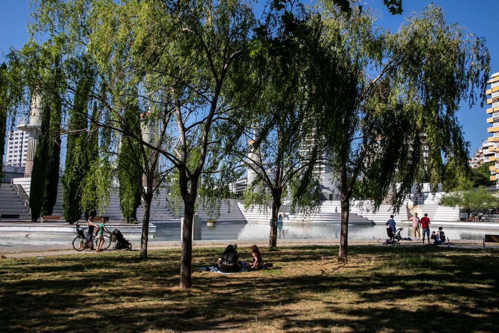 Gent gaudint de la natura al parc de l'Espanya Industrial formant petits grups que guarden les distàncies