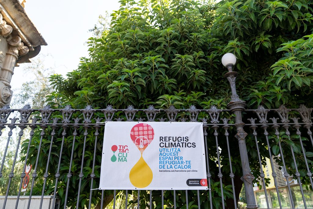 Pancarta de refugis climàtics de la campanya “Tic tac clima” penjant de les reixes del parc de la Ciutadella
