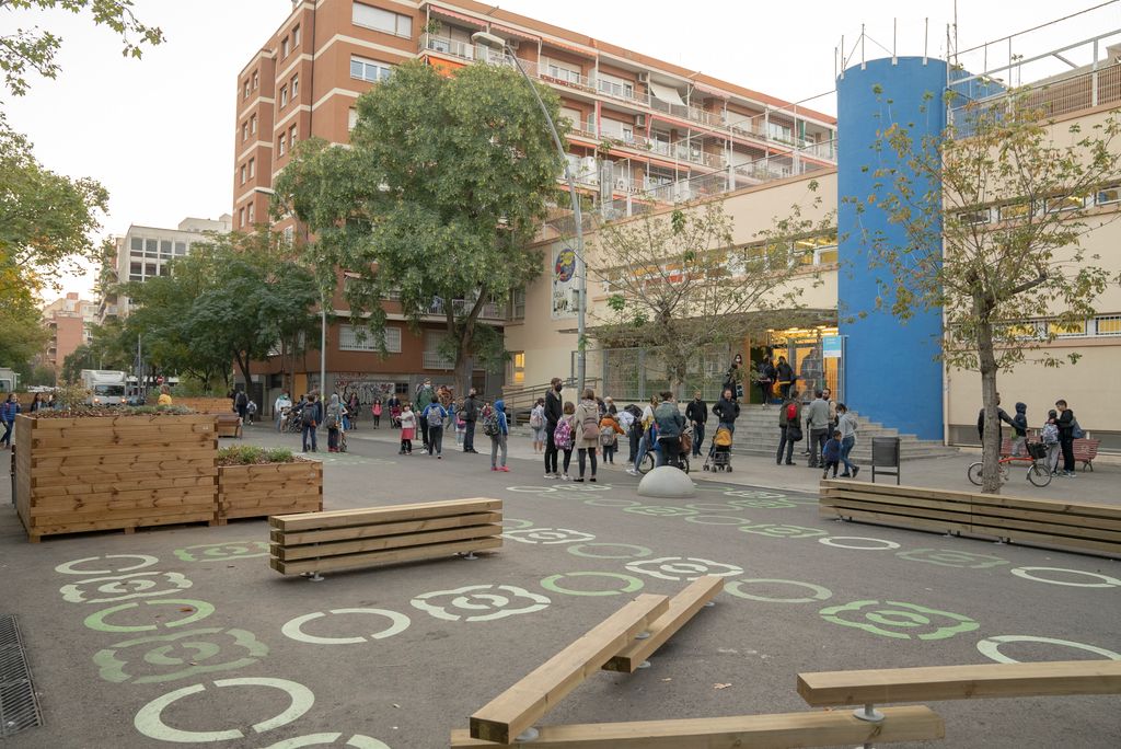Zona pacificada davant de l'Escola Lavínia amb jardineres, bancs i jocs que ocupen la zona on abans circulaven vehicles