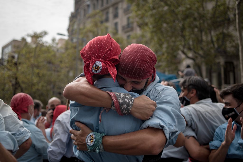 Dos castellers del Poble Sec s'abracen un cop finalitzada l'actuació al matí de festa major de la Mercè 2021