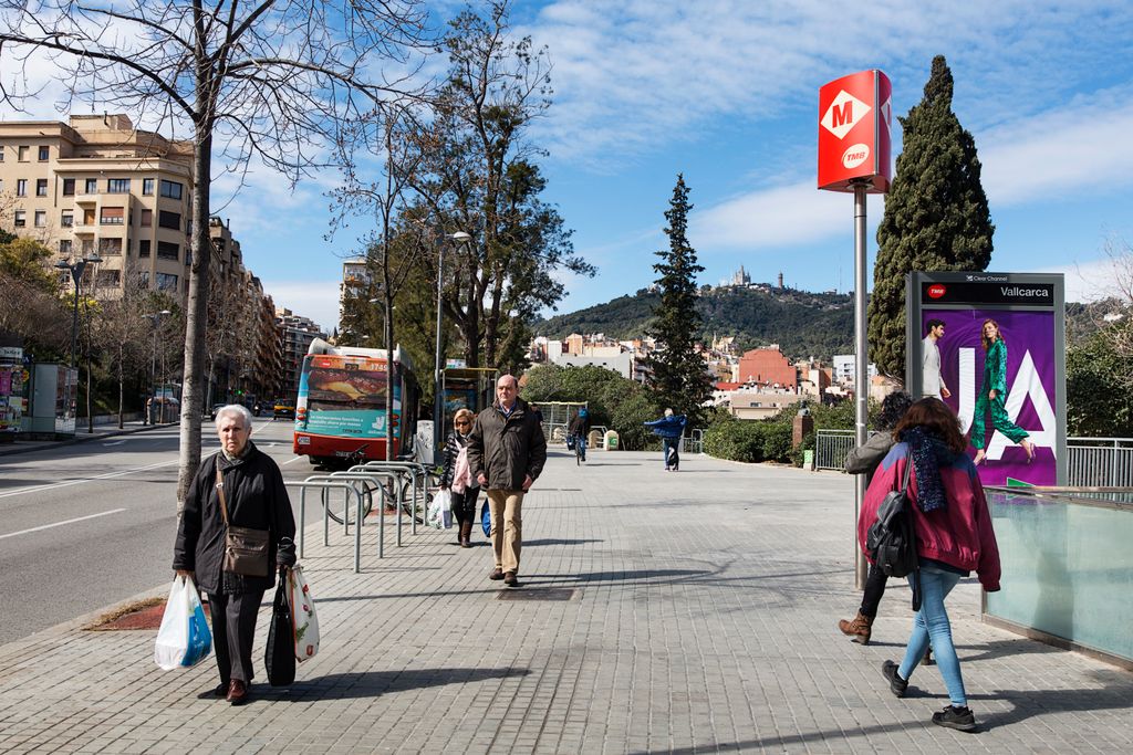 Avinguda de Vallcarca amb l'entrada del metro i vianants caminant per la vorera