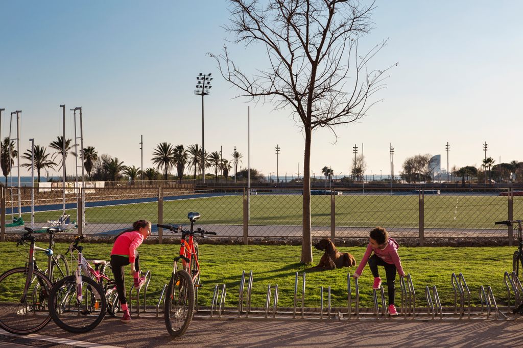 Complex Esportiu Municipal La Mar Bella. Dones fent estiraments a l'aparcament de bicicletes