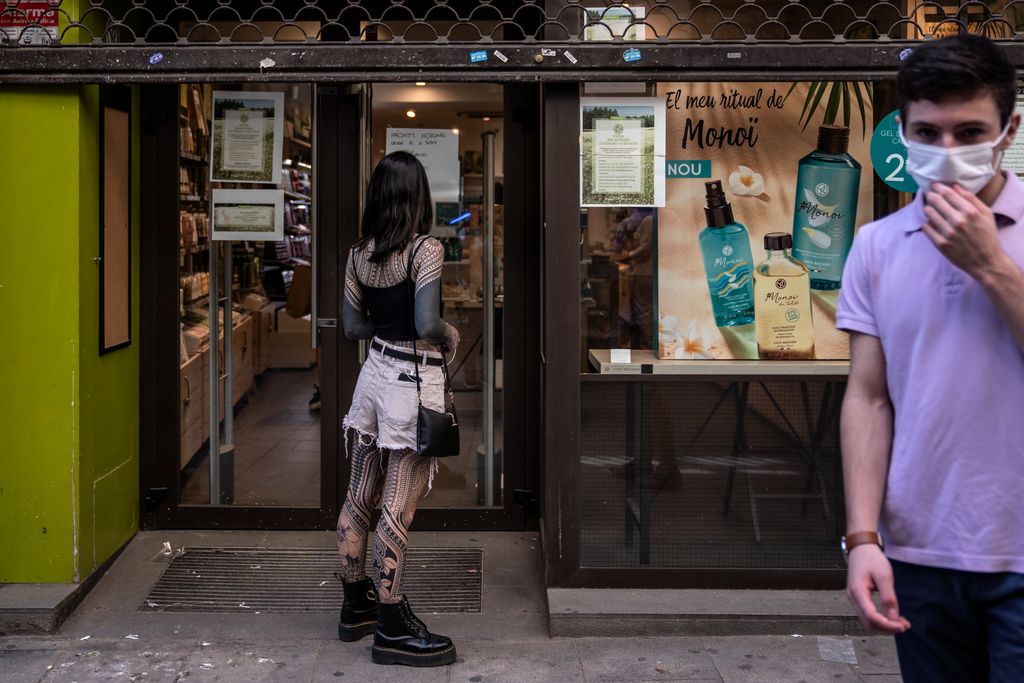 Una jove espera a la porta d'una perfumeria a l'avinguda del Portal de l'Àngel
