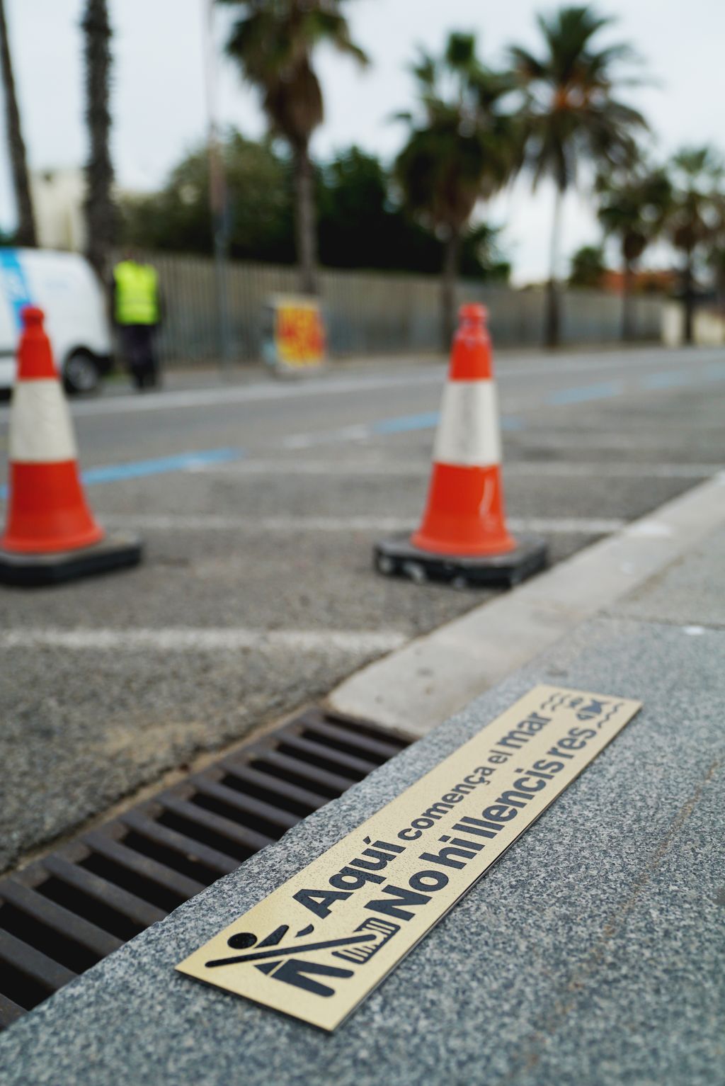 Placa amb el missatge "Aquí comença el mar. No hi llencis res" a la vorera al costat d'un embornal del Passeig Marítim per conscienciar sobre els residus que arriben al mar
