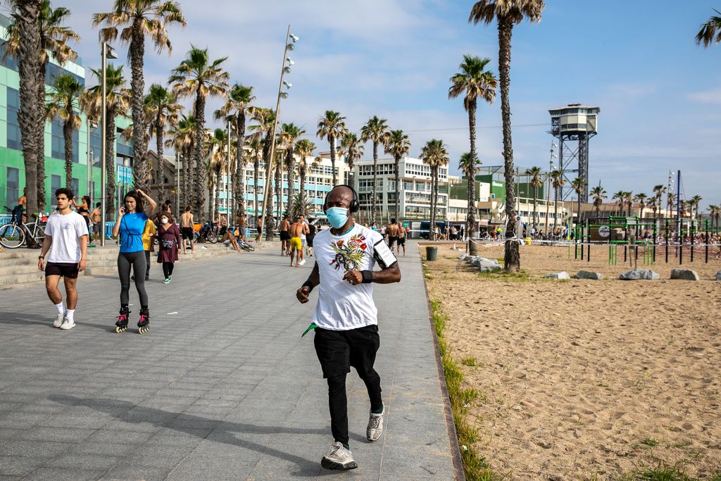 Un home amb mascareta corre pel passeig del Mare Nostrum. Al seu voltant es veu gent caminant i fent esport