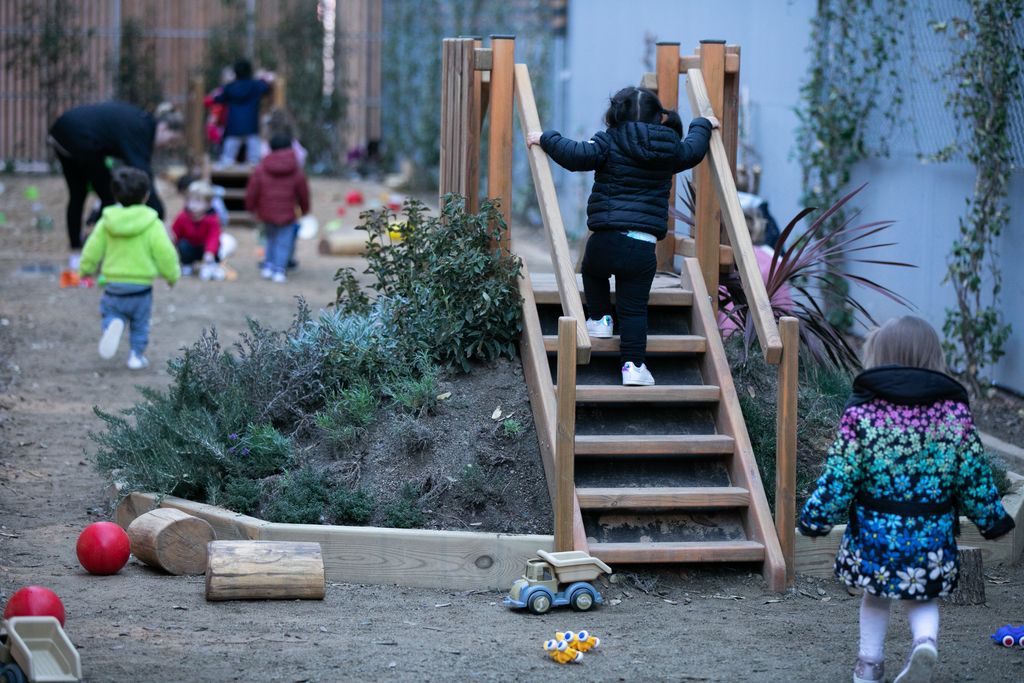 Equipaments, aules i activitat lectiva. Infants jugant amb una varietat de joguines al sorral de l'escola.