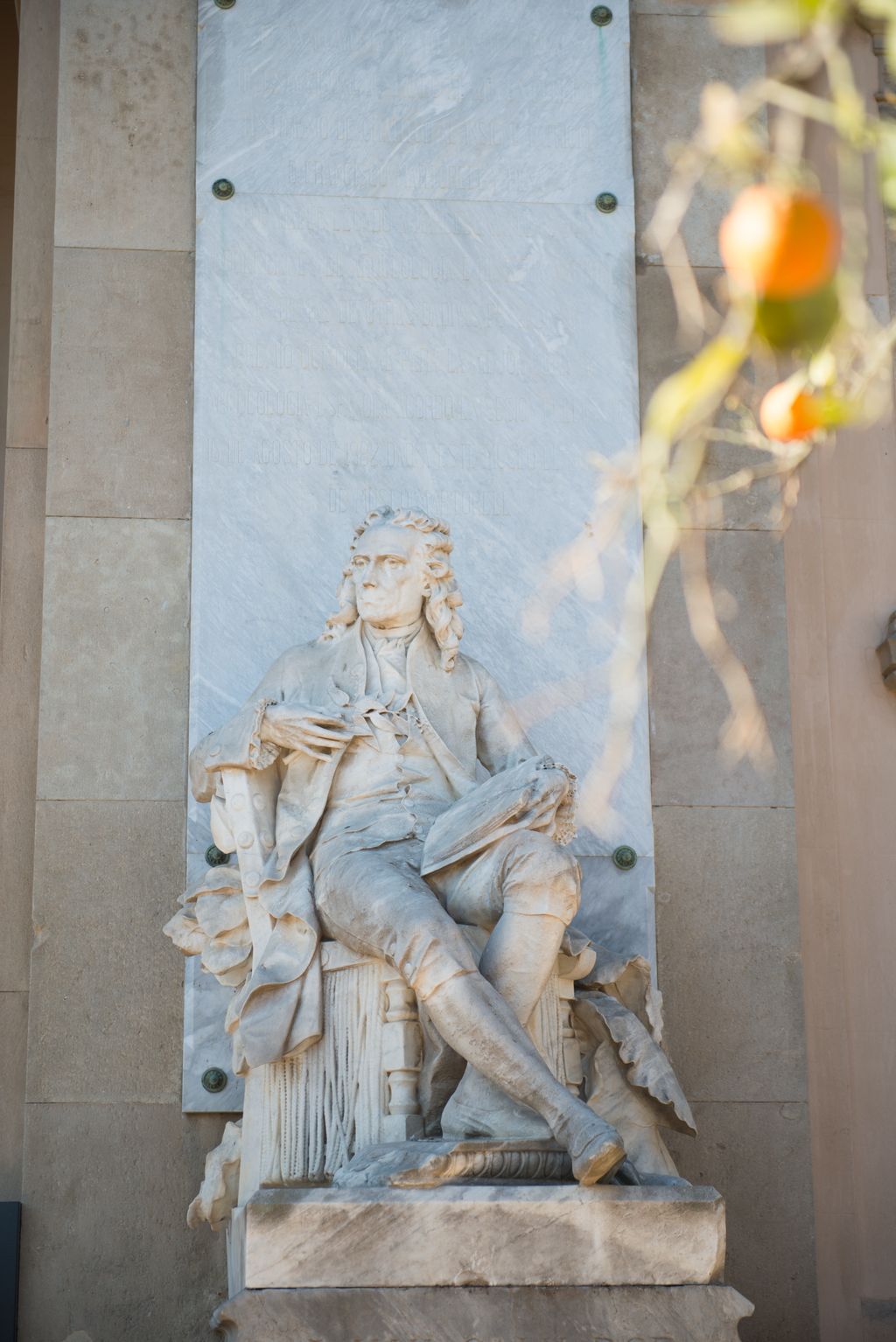 Placa de marbre amb una inscripció i estàtua de Jaume Salvador a l'entrada del Centre Martorell d'Exposicions