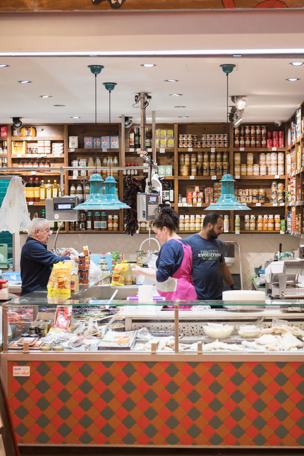 Botiga de queviures on hi ha un home comprant en el Mercat del Ninot, el dia del passeig pel districte de l’Eixample