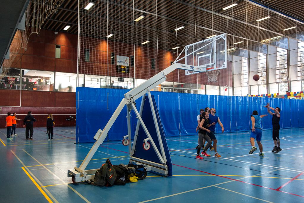Complex Esportiu Municipal La Mar Bella. Homes jugant a bàsquet a les pistes del Pavelló